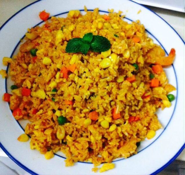 餐桌前的小豆豆做的泰式红咖喱海鲜炒饭