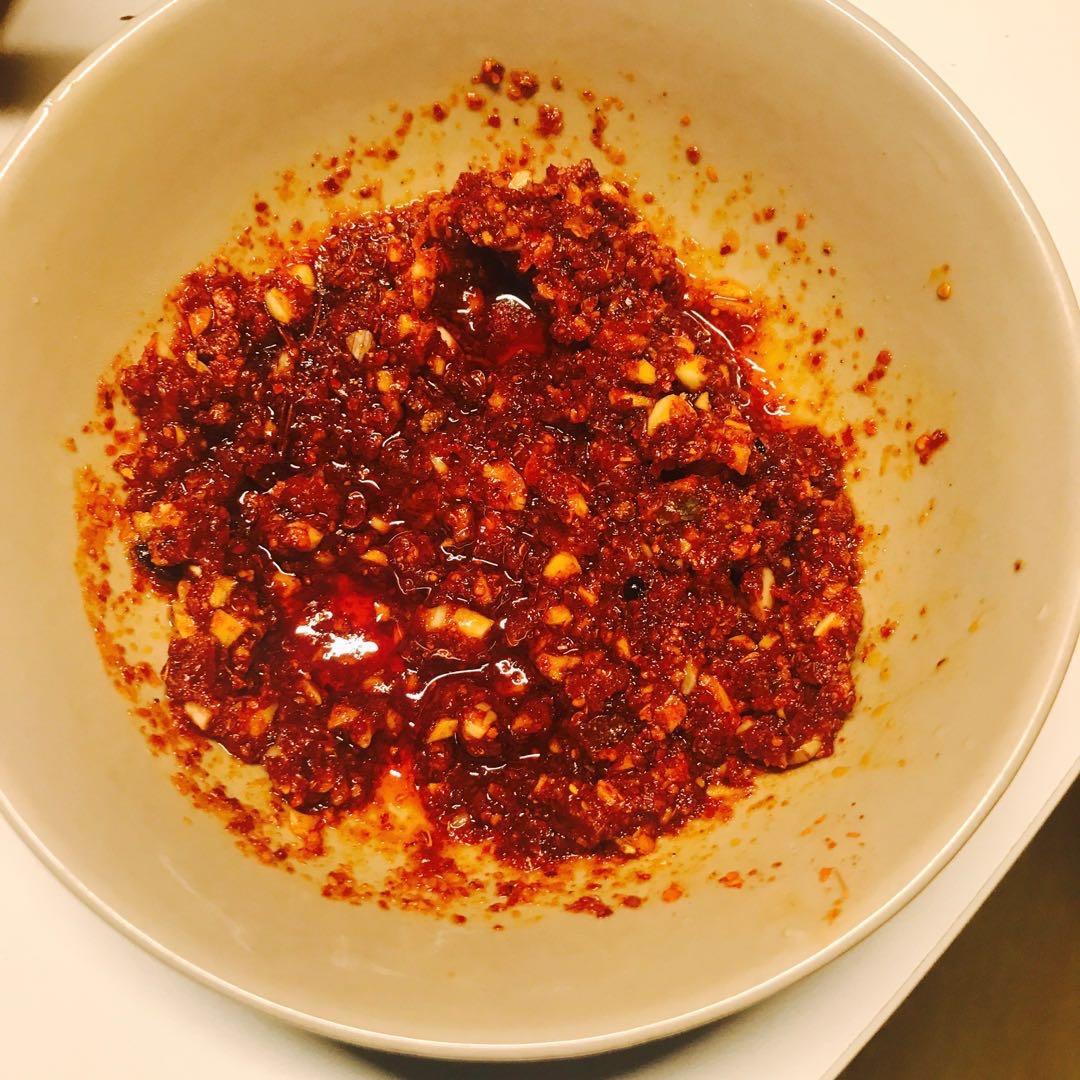 用料辣椒油的做法碗内倒入辣椒面,撒上盐和黑胡椒粉,将蒜泥倒入,滴一