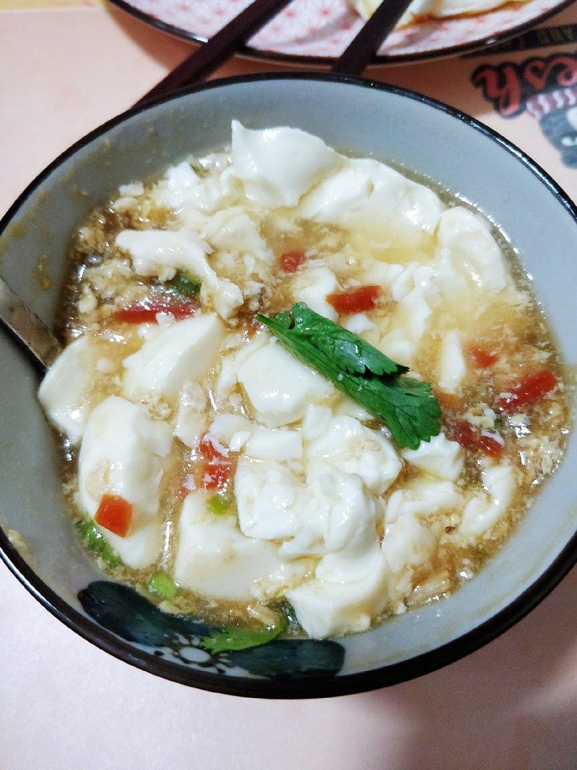 豆腐脑的做法：超市里盒装的内酯豆腐，打开盒放在碗里蒸，然后做豆腐脑的卤汁（虾仁、蘑菇丁加水，加入海鲜酱油、稍许盐，开锅后打入鸡蛋液，用水淀粉勾芡做成浓汁）豆腐蒸好后，倒出多余汤汁，浇上卤汁，一碗干净卫生，营养丰富的豆腐脑就做成了。