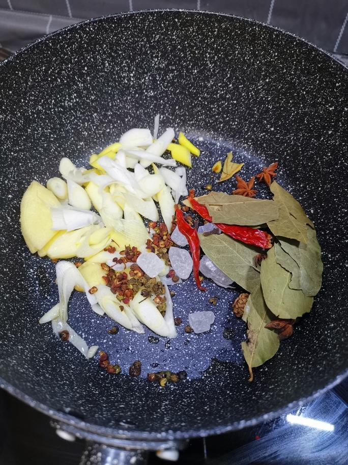 油,把葱姜大料放进去炒制一会儿准备食材,干辣椒2个,花椒3克,麻椒3克