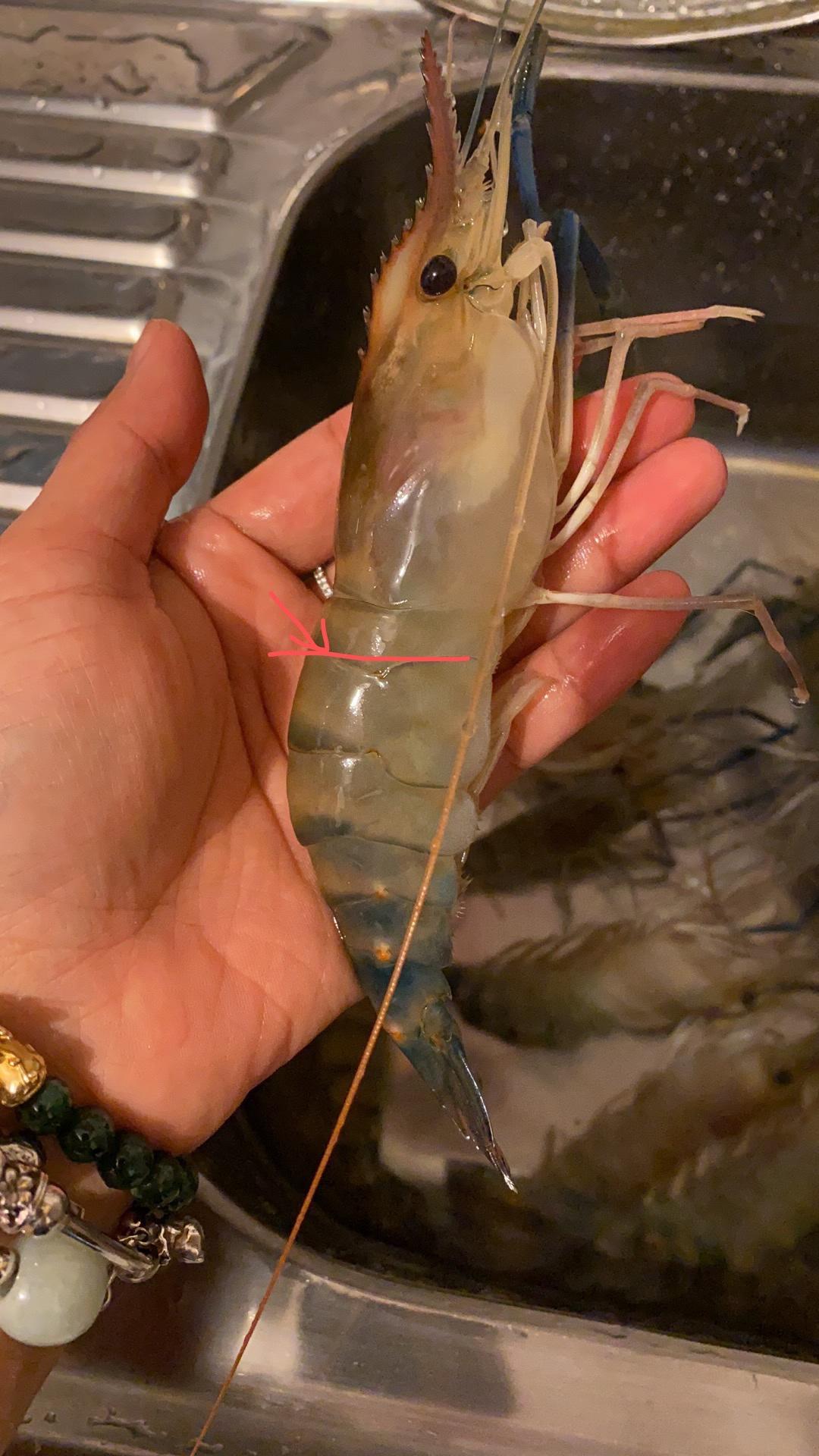 首先剪虾枪,虾脚,然后在虾的这个位置,剪开,挑虾线,别剪太高,要不然等