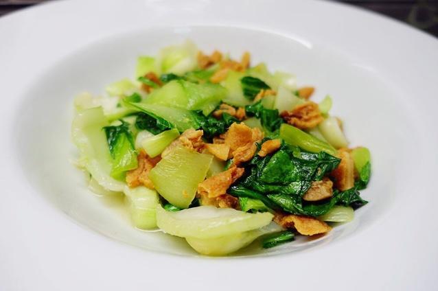 起油锅下青菜帮翻炒然后下入油渣最后放菜叶和调味出锅参照这个菜谱