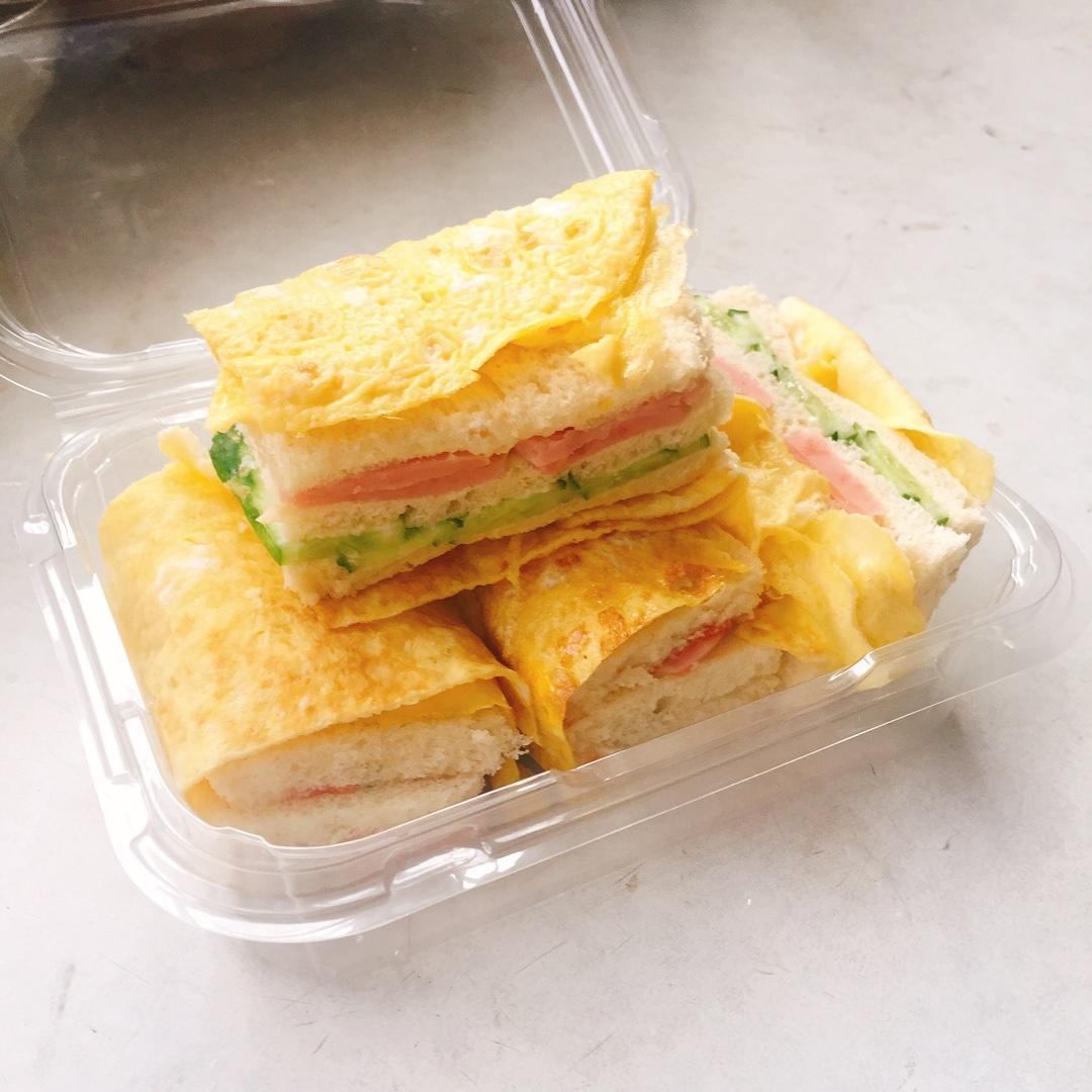 /蛋包三明治/
【材料】
吐司 鸡蛋 火腿 黄瓜 沙拉酱（番茄酱）
【做法】
1、将鸡蛋打入碗中，（三个鸡蛋或两个鸡蛋）静置半分钟
2、平底锅🍳用油将锅底刷一遍，加热后，淋入蛋液并快速晃匀成蛋饼
3、将火腿煎一下，黄瓜切片
4、去掉吐司边，涂上沙拉酱或番茄